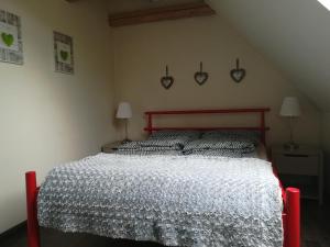 1 dormitorio con 1 cama con edredón blanco y 2 lámparas en Wiejska Chata en Szwalk