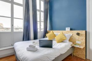 sypialnia z łóżkiem z laptopem w obiekcie NOCNOC-Grand Place-La Perle w Lille