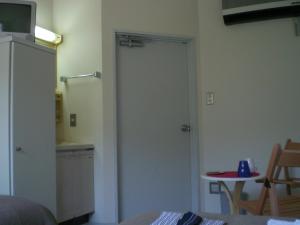 a door in a room with a kitchen with a table at Gallery Court Ofa Atu in Kawazu