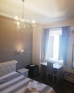 a bedroom with a bed and a desk and a window at B&B The Tower in Tropea