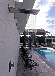 una piscina con sillas y sombrillas junto a un edificio en 6080 Design Hotel by Eskape Collection en Miami Beach