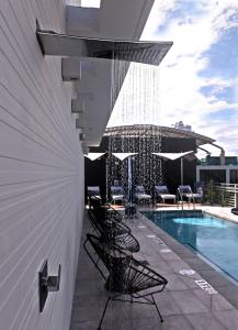 uma piscina com cadeiras e guarda-sóis ao lado de um edifício em 6080 Design Hotel by Eskape Collection em Miami Beach