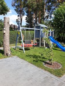 a playground with a slide and a swing at Fe-Wo/Haus Maui bei Berlin m Garten Schulzendorf bei Schönefeld in Schulzendorf