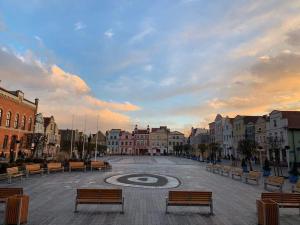 una strada cittadina con panchine e un orologio al centro di PuckApartments a Puck