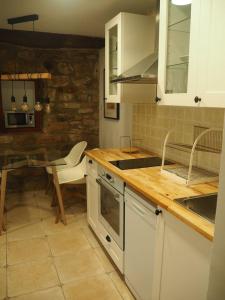 a kitchen with white cabinets and a table and a counter at Piso con encanto en la parte vieja. in Hondarribia