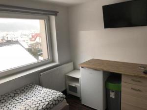 a room with a bed and a desk and a window at Pokoje Gdynia in Gdynia
