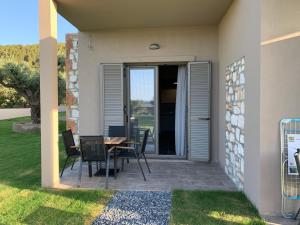 a patio with a table and chairs in front of a house at Castella Apartments in Vourvourou