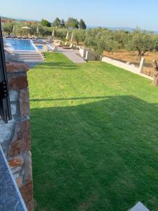 a view of a lawn with a swimming pool at Castella Apartments in Vourvourou