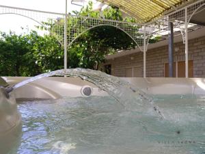 a water fountain in a pool next to a tub at Bed and Breakfast Ivona in Baška Voda
