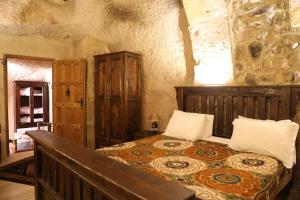 a bedroom with a bed in a stone wall at Hanımkız Konagı in Avanos
