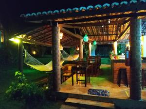 un patio con una hamaca bajo una pérgola por la noche en Vila Pura Vida, en Canoa Quebrada