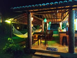 a patio with a hammock under a pergola at night at Vila Pura Vida in Canoa Quebrada