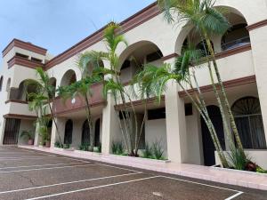 ein Gebäude mit Palmen auf einem Parkplatz in der Unterkunft COLONIAL SUITES # DOS in Ciudad Valles