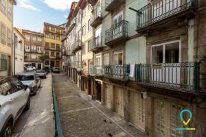 eine schmale Straße mit Gebäuden und Autos darauf geparkt in der Unterkunft Charm in Ribeira in Porto