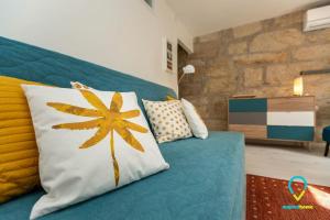 ein Schlafzimmer mit einem blauen Sofa und einem gelben Blumenkissen in der Unterkunft Charm in Ribeira in Porto