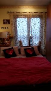 1 dormitorio con cama roja y ventana en Casa tipica valdostana en Aosta