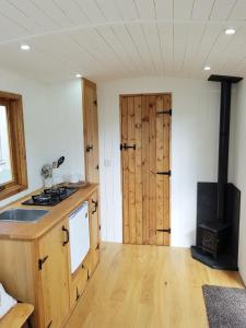 a kitchen with wooden cabinets and a stove top oven at The Llama Hut in Kirk Leavington