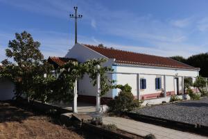 una pequeña iglesia blanca con una cruz en el techo en Monte do Parral, en Santiago do Cacém