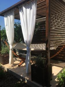 a patio with a table and a white curtain at Dimora La Grazia in Castelvetrano Selinunte