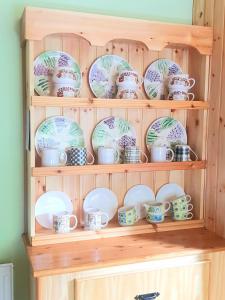 a wooden hutch with cups and plates on it at Leenan View Country House in Portsalon