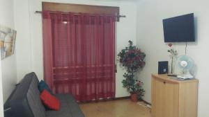 a living room with a couch and a red curtain at Studio Telheiras in Lisbon