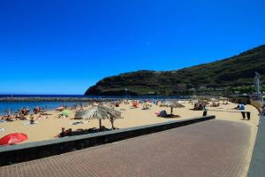 una multitud de personas en una playa con sombrillas en Atlantis Flat. Relaxing Moments, en Machico