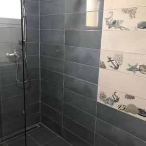 a bathroom with a shower with black tiles at Apartmani Mateja in Kaštela +19 photos