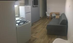 kuchnia z kanapą, kuchenką i lodówką w obiekcie Peschici Appartamento Vacanze w mieście Peschici