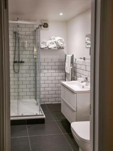 a bathroom with a toilet, sink and shower stall at The Olde Kings Arms in Hemel Hempstead