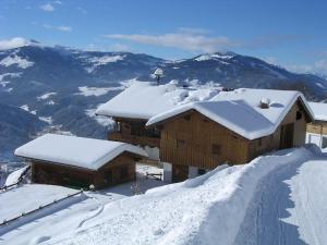 a snow covered building on top of a mountain at Appartement Oberschernthann in Hopfgarten im Brixental