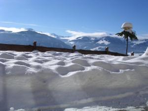 a snow covered roof with mountains in the background at Appartement Oberschernthann in Hopfgarten im Brixental
