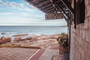 a sign for a seafood restaurant on the beach at Pousada Recanto da Pedra in Iriri