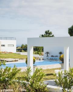 ein weißes Haus mit einem Pool in der Unterkunft Entre Mar e Mar in Aldeia do Meco