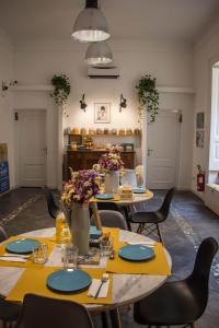 a dining room with tables and chairs with yellow table runners at Borgo Vergini Garden B&B in Naples