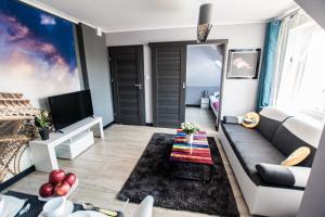 a living room with a couch and a tv at Apartments For You in Lębork