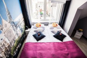 a bedroom with a bed with pillows and a large window at Apartments For You in Lębork