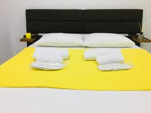- un lit avec 2 serviettes sur une couverture jaune dans l'établissement Yellow room with sea view, à Makhinjauri