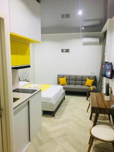 Il comprend une cuisine et un salon avec un lit et une table. dans l'établissement Yellow room with sea view, à Makhinjauri