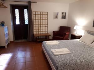 um quarto com uma cama, uma cadeira e uma porta em Quintinha de Santiago em Oliveira de Azemeis