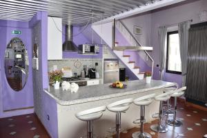 フィレンツェにあるThe Black Sheep B&Bの紫の壁のキッチン、カウンター(スツール付)