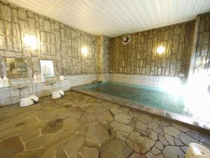 a large bathroom with a swimming pool in a room at Hotel Route-Inn Shimada Ekimae in Shimada