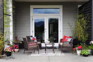 um alpendre com cadeiras de vime e uma porta de vidro em Valley View em Lake Cowichan