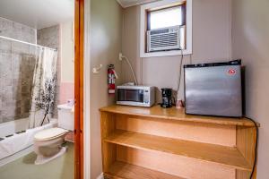 a bathroom with a toilet and a microwave on a counter at Long Sault Motel in Long Sault