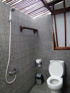 a bathroom with a toilet and a shower at Mirna Homestay in Gili Air
