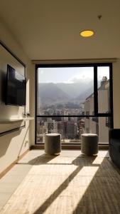 ein Wohnzimmer mit einem großen Fenster mit Aussicht in der Unterkunft Luxury Residence Suites in Quito