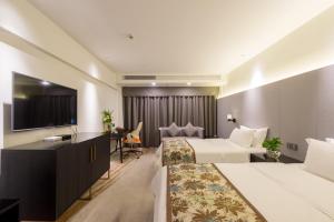 a hotel room with two beds and a flat screen tv at Dashen Hotel Shunde Lecong in Shunde