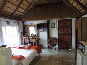 a bedroom with a bed and a kitchen with a refrigerator at Karibu River Retreat in Marble Hall