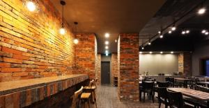 a restaurant with tables and chairs and a brick wall at Hotel Mondavi in Mokpo