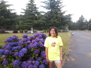 a woman standing in front of purple flowers at Fuller Lake Chemainus Motel in Chemainus