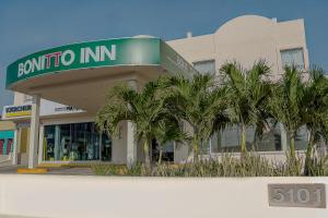 a building with palm trees in front of it at BONITTO INN® Tampico Lomas in Tampico